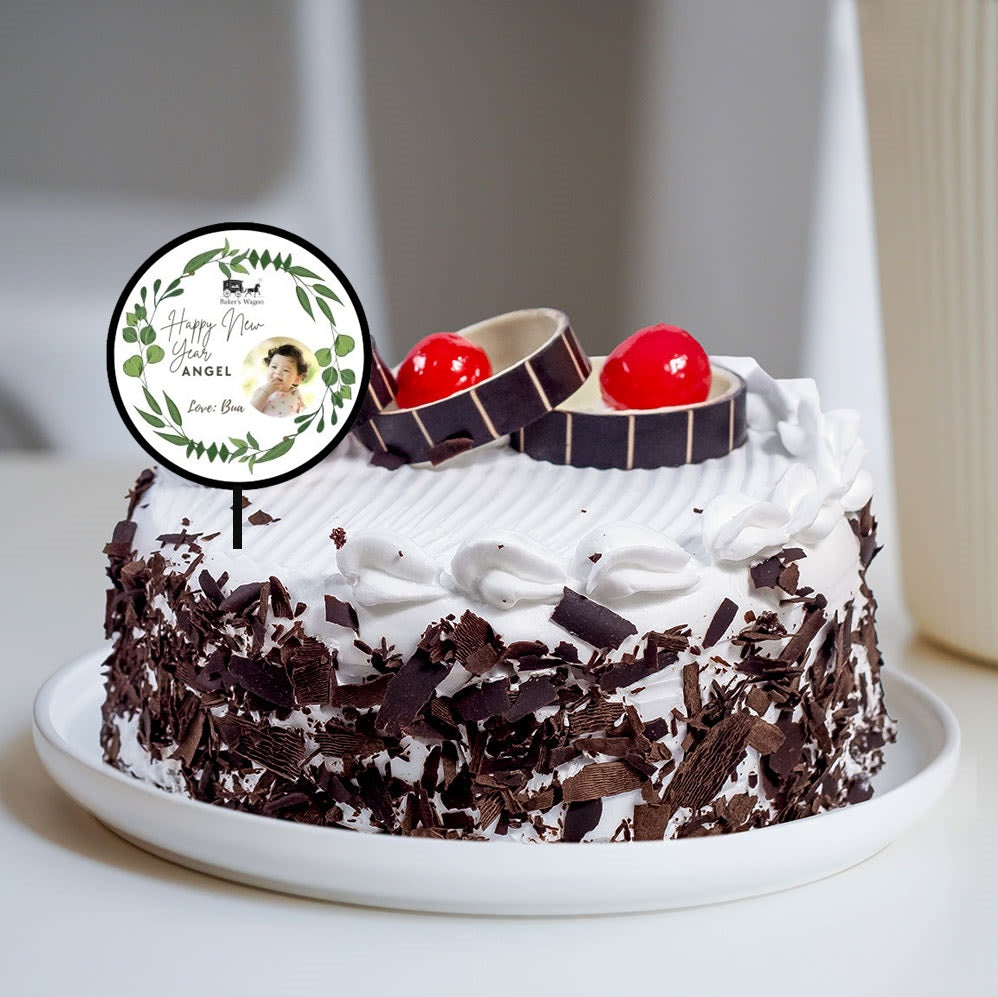 Gift New Year Special Black Forest Cake along with customised topper from Bakers WAgon